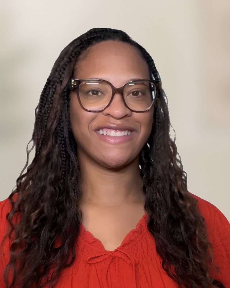 Magan Strickland, smiling, in glasses and a red blouse.